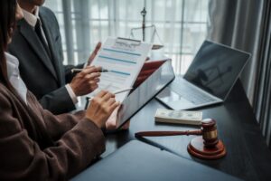 Lawyer explaining a legal contract to a business client at a desk.